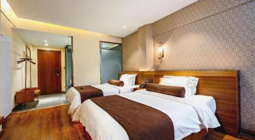 a hotel room with two beds in a room at James Joyce Coffetel Qufu Tourist Center Gulou Street Sankong Scenic Spot in Jining