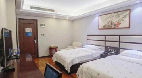 a hotel room with two beds and a television at Li An Hotel Shantou Xiashan Central Bus Station Branch in Shantou