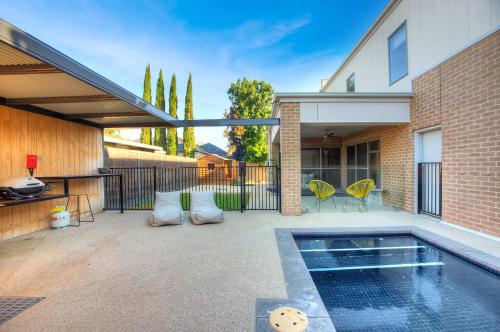 a patio with a swimming pool and a house at Mandel on High - Echuca Holiday Homes in Echuca