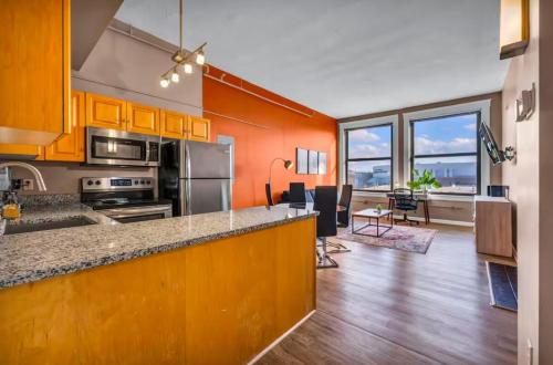 a kitchen with orange walls and a kitchen with a counter at 1Br in Heart of Downtown, Sauna, Prime Location in Cleveland