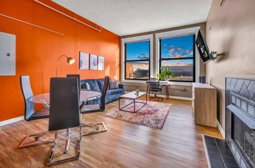 a living room with orange walls and a table and a couch at 1Br in Heart of Downtown, Sauna, Prime Location in Cleveland