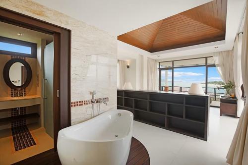 a bathroom with a large white tub and a mirror at Six Hills Villa - A Private Sanctuary of Elegance in Amphoe Koh Samui
