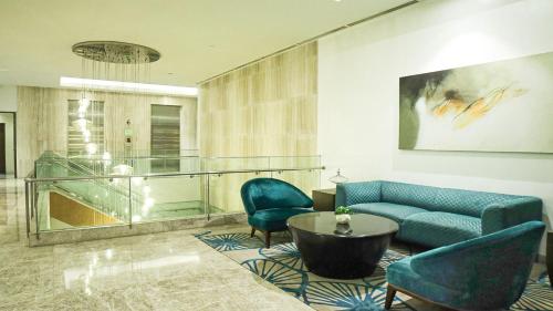a living room with a couch and two chairs and a table at Private Rooms in Historic Manila Chinatown in Manila