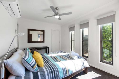 a bedroom with a bed and a ceiling fan at Mandel on High - Echuca Holiday Homes in Echuca