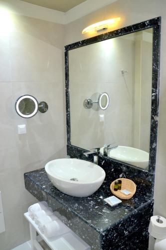 a bathroom with a sink and a mirror at Zephyros Hotel in Kamari