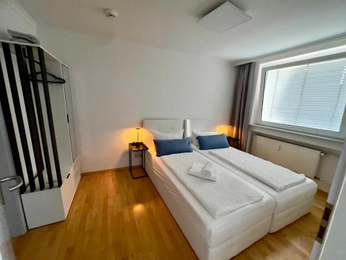 a bedroom with a large white bed with blue pillows at Rheinstraße 33, Mainz mit Domblick in Mainz