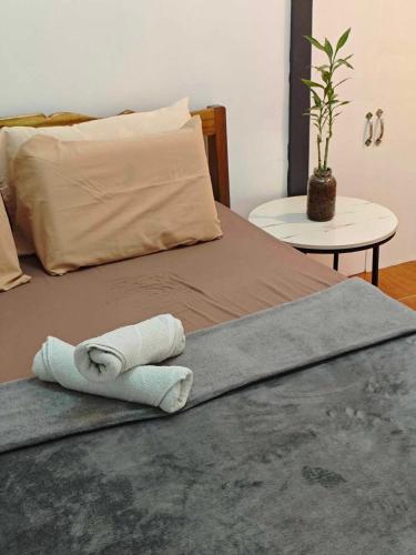 a bed with two rolled towels on top of it at Alexa's Apartments in El Nido