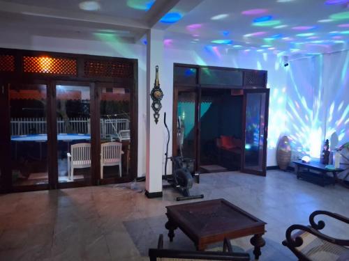 a living room with a table and a large aquarium at Villa Camellia Garland 3 room beach house in Ambalangoda