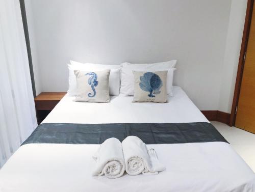 a bed with white sheets and white shoes on it at Beachfront 120sqm 2BR with Private Plunge Pool on stunning Naithon beach in Nai Thon Beach