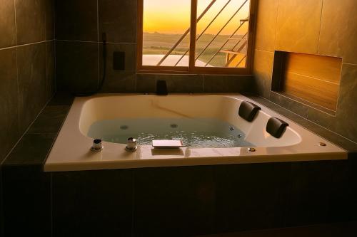 a bath tub in a bathroom with a window at Cabaña, Terraza, Casa, Campo, Jacuzzi y Tranquilida Total in Arandas