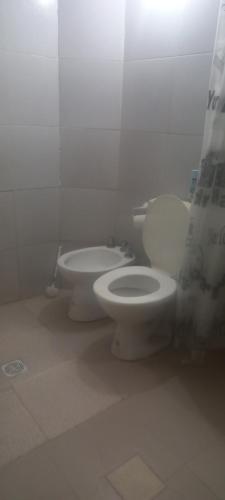 een badkamer met 2 toiletten en een douchegordijn bij Ale Rivero in Salta
