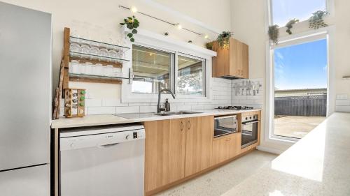 a kitchen with wooden cabinets and a window at The Loft in Culburra Beach