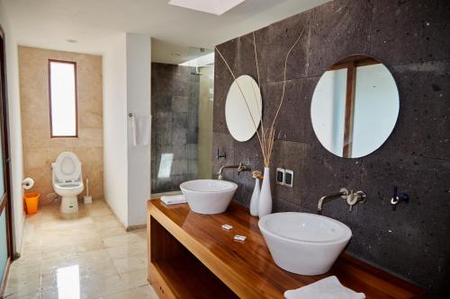 a bathroom with two sinks and two mirrors at Yacht House in Cancún