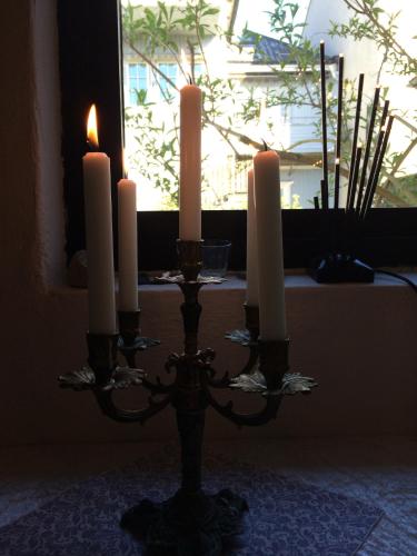 a candlestick with three candles on it in front of a window at Villa Tullgatan Borgholm in Borgholm