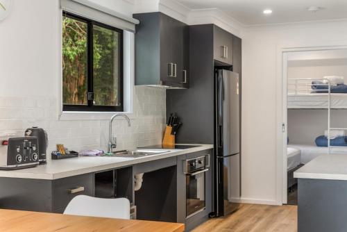 a kitchen with a sink and a refrigerator at BIG4 Yarra Valley Park Lane Holiday Park in Healesville