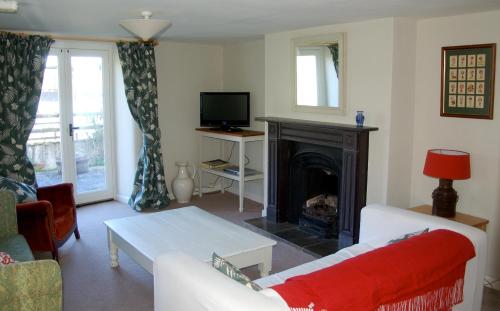 a living room with a couch and a fireplace at Old Orchard Cottage in Colyton