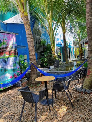 a table and chairs and palm trees in a patio at Khu Nghỉ Dưỡng Thuần Chay MIND LINK 