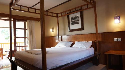 a bedroom with a canopy bed with a porch at Grand Desa Resort in Cimaja