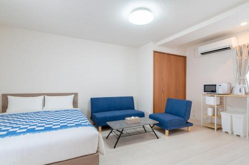 a bedroom with a bed and two blue chairs at -Park Higashiueno301- 4-minute walk from Ueno Station in Tokyo