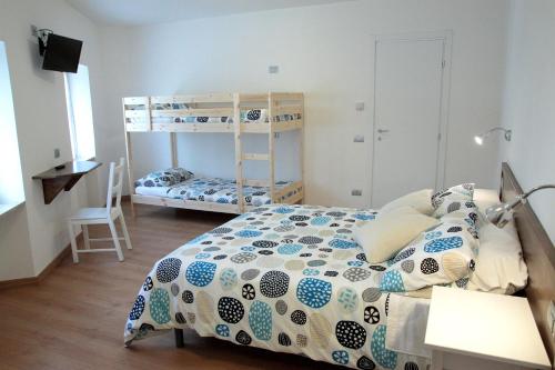 ein Schlafzimmer mit einem Bett und einem Etagenbett in der Unterkunft Locanda Il Gigante in Collagna