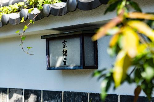 a lantern on the side of a building with writing on it at Kyotoya in Takeo