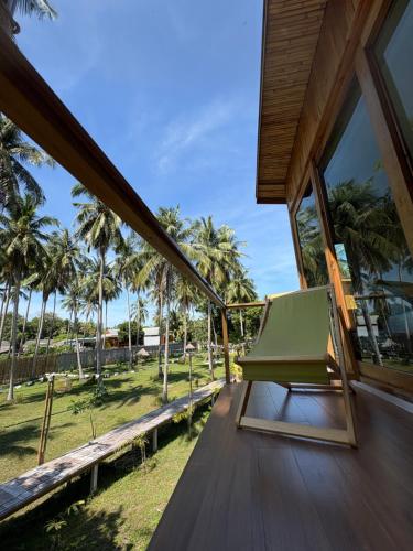 a room with a view of the ocean and palm trees at บ้านพราวพร้าว Baan Proud Proud in Khanom