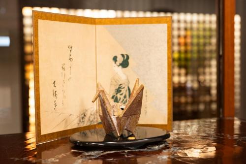 a figurine of a woman on a table next to a picture at Kyotoya in Takeo