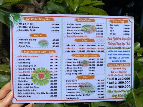 a person holding up a menu for a restaurant at Khu Nghỉ Dưỡng Thuần Chay MIND LINK 