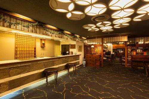 a restaurant with a bar with stools and tables at Kyotoya in Takeo