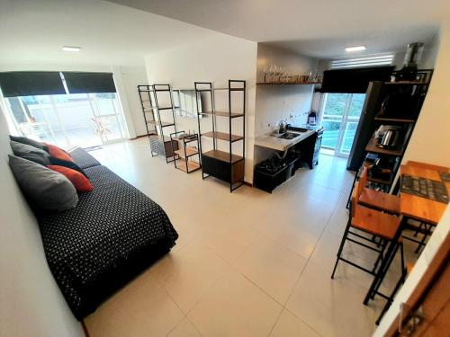 a living room with a couch and a kitchen at Apartamento Cobertura vista ao mar churrasqueira Prainha Arraial do Cabo in Arraial do Cabo
