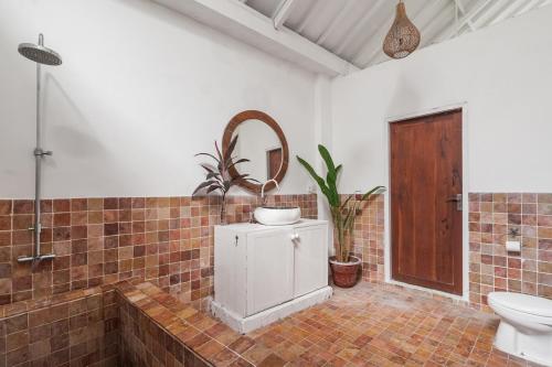 a bathroom with a toilet and a sink and a mirror at European-Inspired Villa Near Beach & Dining in Gili Trawangan