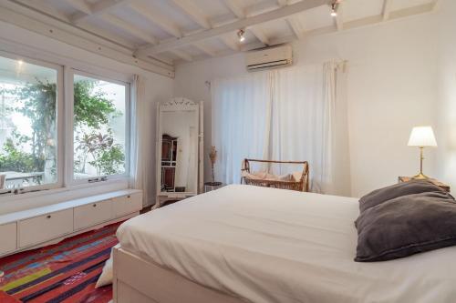 a white bedroom with a large bed and a window at European-Inspired Villa Near Beach & Dining in Gili Trawangan