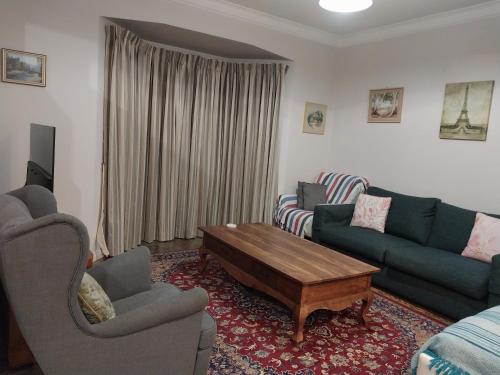 a living room with two couches and a coffee table at Sweet Holiday Home by the Golf Course in Canberra