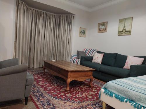 a living room with a couch and a coffee table at Sweet Holiday Home by the Golf Course in Canberra