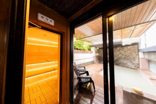 a door to a porch with a bench on a deck at Kyotoya in Takeo