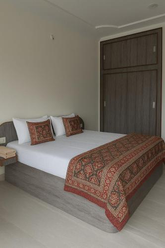 a bedroom with a large bed with a wooden door at Viren Niwas in Ajmer