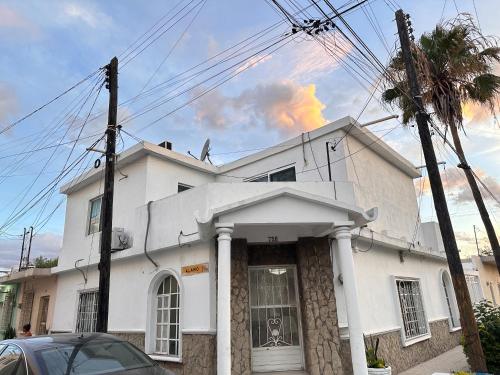 a white house with a palm tree in front of it at Loft de Lujo cerca de la Arena Monterrey y Barrio Antiguo in Monterrey