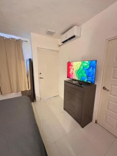 a bedroom with a flat screen tv on a dresser at Loft de Lujo cerca de la Arena Monterrey y Barrio Antiguo in Monterrey