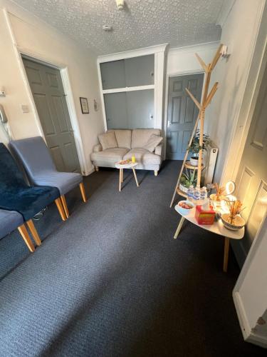 a living room with a couch and a table at The Bungalow by SJP - Twin Room in Kettering