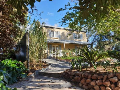 an exterior view of a house with a stone wall at Dennis Cottage Clare Valley in Auburn