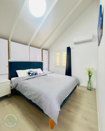 a bedroom with a large bed with a blue headboard at Bungalow Carioca Vue mer piscine privée au calme in Le Robert