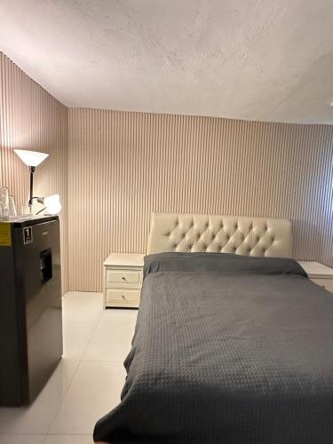 1 dormitorio con 1 cama grande y nevera en Loft de Lujo cerca de la Arena Monterrey y Barrio Antiguo, en Monterrey