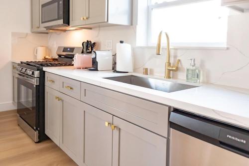 a white kitchen with a sink and a stove at Unique 4-bedroom House 3-levels in Los Angeles