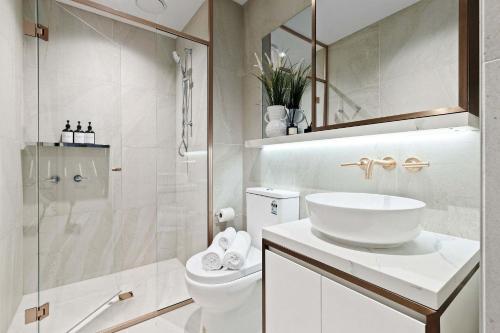 Un baño con inodoro, lavabo y ducha. en A Cozy 2BR Apt Right on Buzzing Chapel Street, en Melbourne