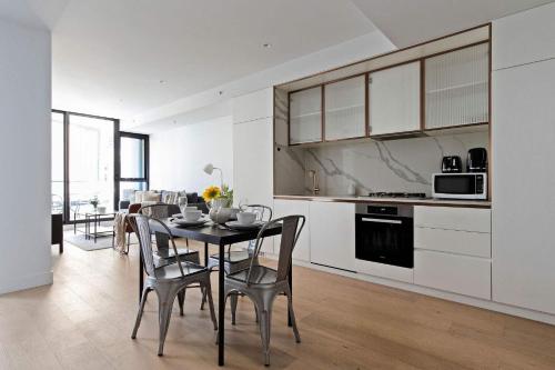 Una cocina y un comedor con mesa y sillas. en A Cozy 2BR Apt Right on Buzzing Chapel Street, en Melbourne