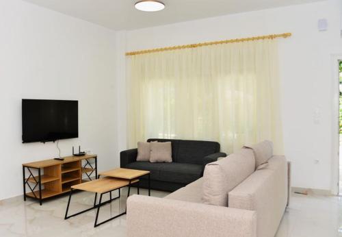 a living room with a couch and a tv at Nurit private apartment in Limenas