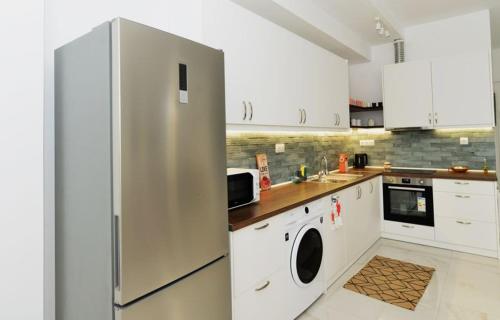 a kitchen with a refrigerator and a washer and dryer at Nurit private apartment in Limenas