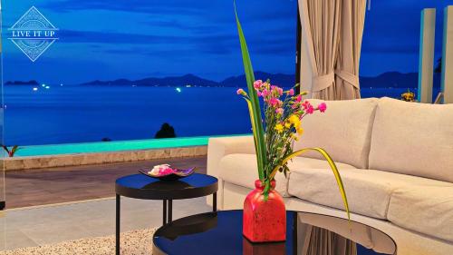 un soggiorno con un divano e un tavolo con fiori di Santi Vista Villas a Ko Samui