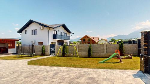 un patio trasero con un parque infantil con un columpio en D&M Family Residence Bran 2, en Bran