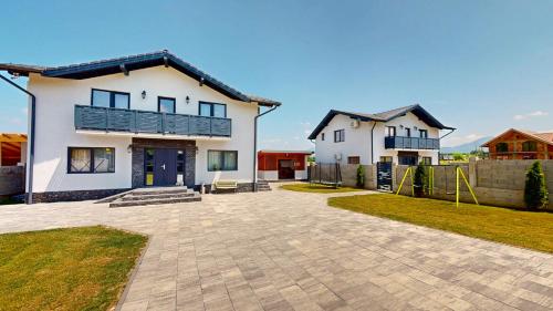 Una gran casa blanca con un parque infantil enfrente. en D&M Family Residence Bran 2, en Bran